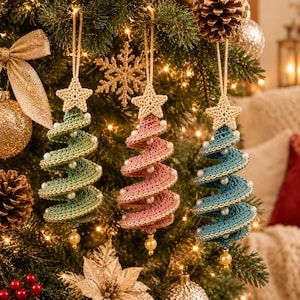May include: Three spiral-shaped crochet Christmas tree ornaments in sage green, dusty pink, and teal blue. Each ornament features a beige crocheted star at the top, white pearl-like beads along the spiral edges, and a single gold bead at the base.