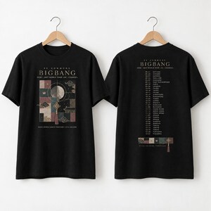 May include: A black short-sleeve t-shirt shown from the front and back. The front features a graphic with a moon, clouds, and the text BIGBANG 2026-2027 WORLD TOUR. The back lists tour dates and cities with the text BIGBANG 2026-2027 WORLD TOUR.