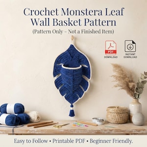 May include: A crochet Monstera leaf wall basket pattern featuring a dark blue leaf-shaped basket with a cream-colored border and tassel. The text reads Crochet Monstera Leaf Wall Basket Pattern, Pattern Only - Not a Finished Item, and Instant Download.