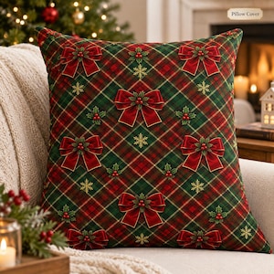 May include: A square pillow cover featuring a dark green and red plaid pattern. The design is decorated with repeating red satin bows, clusters of green holly leaves with red berries, and small gold snowflakes scattered across the fabric surface.