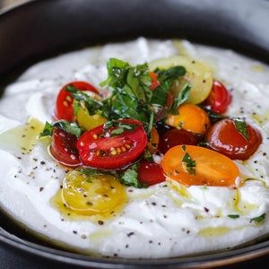 Warm, whipped cottage Cheese with Basil, tomatoes, olive oil and a drizzle of Balsamic.