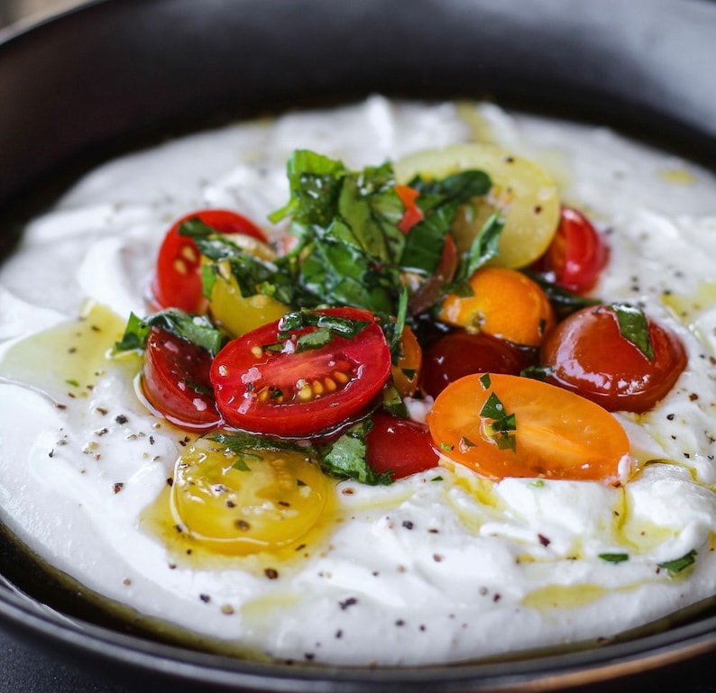 Warm, whipped cottage Cheese with Basil, tomatoes, olive oil and a drizzle of Balsamic.