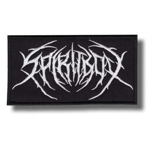 Puede incluir: Un parche rectangular bordado en negro que presenta el texto blanco SPIRITBOX en una fuente estilizada, dentada y espinosa. El diseño está centrado sobre la tela, la cual tiene un borde cosido visible, creando un aspecto gráfico contrastado.