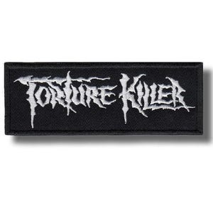 Könnte beinhalten: Ein rechteckiger bestickter Aufnäher mit schwarzem Hintergrund und weißem Garn. Der Text Torture Killer ist in einer gezackten, stilisierten Schriftart in der Mitte des Aufnähers gestickt. Die Kanten sind mit einem schwarzen Rand versehen.