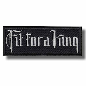 May include: A rectangular black embroidered patch featuring the white text Fit for a King in a stylized gothic font. The patch has a thick black border and a textured fabric surface, designed for application to clothing or accessories as a decorative element.