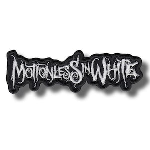 Op de afbeelding: Een rechthoekige geborduurde patch met de tekst Motionless In White in een gestileerd, grillig wit lettertype. De tekst staat op een zwarte achtergrond met een dikke, gecontourde zwarte rand die de vorm van de letters volgt.