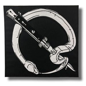 May include: A square black embroidered patch featuring a white snake coiled in a circle, pierced by a black and white switchblade knife. The design is rendered in high-contrast thread, showcasing the detailed scales of the snake and the metallic structure of the knife blade and handle.