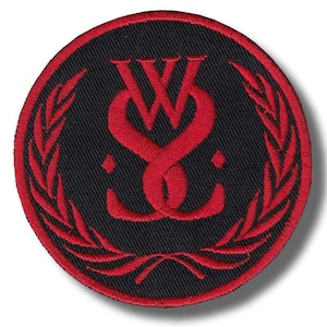 May include: A circular embroidered patch featuring a black background with a red border. The center displays a stylized red monogram of the letters W and S intertwined, flanked by two red laurel leaf branches that curve along the circular edge.