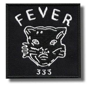 May include: A square black embroidered patch featuring white stitching. The design includes the word FEVER arched above a stylised cat face graphic, with the number 333 embroidered in white below the cat face on a black fabric background.