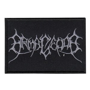 May include: A rectangular black embroidered patch featuring light grey thread forming stylised, jagged, and symmetrical lettering across the centre. The design has a thick, stitched border and a textured fabric base, creating a high-contrast appearance.