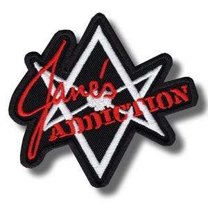 Op de afbeelding: Een geborduurde patch met een zwart-witte stervorm met een dikke zwarte rand. De rode tekst Jane's Addiction is in het midden geborduurd in een combinatie van cursief en blokletters, wat zorgt voor een opvallend grafisch ontwerp.