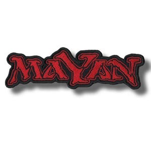 May include: An embroidered patch featuring the word MAYAN in bold, stylized red lettering with a thick black border. The text has a jagged, sharp-edged font style with a textured thread finish, creating a distinct contrast between the red and black.