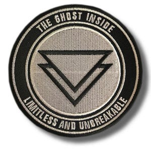 Könnte beinhalten: Ein kreisförmiger bestickter Aufnäher in Schwarz und Grau. In der Mitte befinden sich zwei übereinanderliegende schwarze Dreiecke. Der Text THE GHOST INSIDE ist oben gebogen, und LIMITLESS AND UNBREAKABLE ist unten in Weiß auf Schwarz.