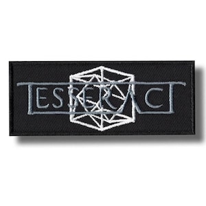 Op de afbeelding: Een rechthoekige zwarte geborduurde patch met het woord TESSERACT in lichtgrijze hoofdletters. Een wit geometrisch draadmodel van een kubus is gecentreerd achter de tekst, met een horizontale lijn die over de hele patch loopt.