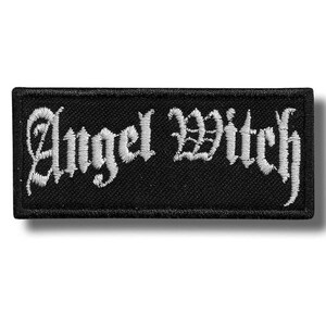 Op de afbeelding: Een rechthoekige zwarte geborduurde patch met de witte tekst Angel Witch in een gestileerd gotisch lettertype. De patch heeft een effen zwarte rand en een achtergrond van textuurstof, met de letters gestikt in contrasterend wit garen.