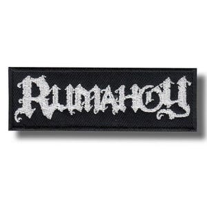 Op de afbeelding: Een rechthoekige zwarte geborduurde patch met het woord Rumahoy gestikt in een wit, gestileerd, grillig gotisch lettertype. De patch heeft een strakke, afgewerkte rand en een plat, getextureerd oppervlak voor bevestiging op textiel.