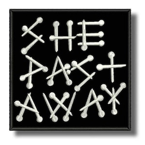 Op de afbeelding: Een vierkante zwarte geborduurde patch met de witte tekst "SHE PAST AWAY", gestileerd met spijkerachtige vormen. De letters zijn gevormd door kruisende witte lijnen met afgeronde uiteinden, wat een scherp contrast vormt met de zwarte achtergrond.