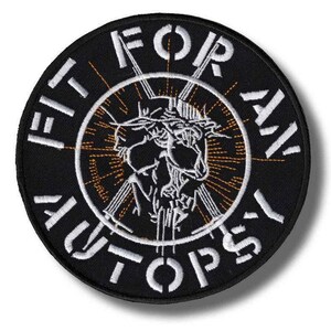May include: A circular black embroidered patch featuring white text that reads FIT FOR AN AUTOPSY around the border. The center displays a white stitched graphic of a figure wearing a crown of thorns, surrounded by thin orange radiating lines.