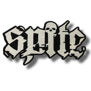 Op de afbeelding: Een geborduurde patch met het woord SPITE in een grillig, wit gotisch lettertype met een dikke zwarte rand. Een klein, gedetailleerd wit schedelpictogram is boven de letter I geplaatst en vervangt de punt van de letter.