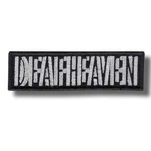 May include: A rectangular embroidered patch with a black background and white stitched text that reads "DEFENESTRATION" in a bold, sans-serif font. The patch features a clean, finished border and is oriented horizontally against a plain background.