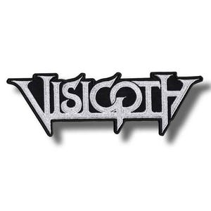 May include: A rectangular embroidered patch featuring the word VISIGOTH in a stylized, sharp-edged white font with a black border. The lettering has a distinct, angular design with elongated points on the outer letters and a circular center.