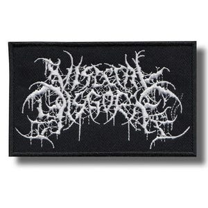Könnte beinhalten: Ein rechteckiger, schwarz bestickter Aufnäher mit weißem Garn, das den Text Visceral Disgorge in einer stilisierten, gezackten und komplexen Schrift bildet. Das Design hat ein dichtes, spinnennetzartiges Aussehen mit scharfen Kanten.