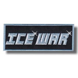 Könnte beinhalten: Ein rechteckiger bestickter Aufnäher mit schwarzem Hintergrund und hellblauem Rand. Der Text ICE WAR ist in metallisch hellblauem Garn in Blockschrift gestickt und weist einen kleinen vierzackigen Stern als Akzent auf den Buchstaben E und R auf.