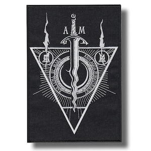 以下が含まれることがあります： 中央に波打つ剣とAとMの文字が刺繍された、長方形の黒いワッペン。大きな三角形が、ラテン語のテキスト、放射状の線、煙を伴う2つの小さな円形アイコンが描かれた円形エンブレムを囲んでいるデザイン。