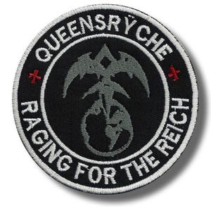 Puede incluir: Un parche bordado circular con fondo negro y borde blanco. Presenta el texto QUEYSRYCHE y RAGING FOR THE REICH en letras blancas, con dos pequeñas cruces rojas y un emblema central gris que representa un globo terráqueo y un águila.