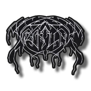 Pode incluir: Um emblema bordado preto com letras brancas estilizadas num design complexo, angular e a escorrer. O texto está inserido numa moldura oval com linhas alongadas e fluidas que se estendem para baixo, criando uma estética nítida e detalhada.