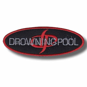Può includere: Una toppa ricamata di forma ovale con sfondo nero e bordo rosso. Il testo DROWNING POOL è ricamato in bianco al centro, sovrapposto a un simbolo grafico rosso stilizzato che ricorda una forma a S curva e astratta.