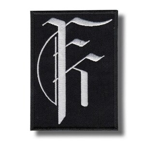 Op de afbeelding: Een rechthoekige zwarte geborduurde patch met een grote, witte, gestileerde gotische letter F. Het ontwerp is gecentreerd op de stof, met een dikke zwarte rand die het hele stuk omlijst. Het borduurwerk heeft een zichtbare textuur en strakke randen.
