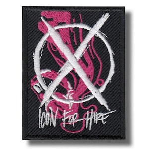May include: A rectangular black embroidered patch featuring a white circular emblem with a large white X across the center. Behind the emblem is a pink abstract design. The text Icon For Hire is embroidered in white at the bottom of the patch.