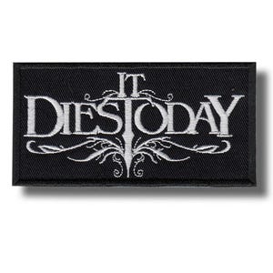 Puede incluir: Un parche rectangular bordado en negro con el texto blanco IT DIES TODAY en una fuente estilizada. El diseño incluye un elemento central vertical en forma de espada integrado en las letras, rodeado de intrincados adornos filigranados.