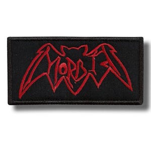 May include: A rectangular black embroidered patch featuring a red stitched bat silhouette with the text MORBID integrated into the wing design. The patch has a thick black border and a textured fabric surface with detailed red thread embroidery.