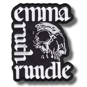 May include: A black embroidered patch featuring white text that reads "emma" at the top and "rundle" at the bottom. The center of the patch displays a detailed white graphic illustration of a human skull, all set against a solid black background.