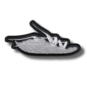 May include: An embroidered patch featuring a stylized hand gesture with the middle finger extended. The design is rendered in silver-gray thread for the hand and fingers, outlined with a thick, bold black border to define the shape clearly.