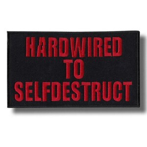 May include: A rectangular black embroidered patch featuring the text HARDWIRED TO SELFDESTRUCT in bold red capital letters. The design is centered on a dark fabric background with a clean, stitched border, creating a high-contrast visual effect.
