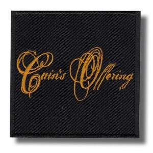 Op de afbeelding: Een vierkante zwarte stoffen patch met een afgewerkte rand, voorzien van de tekst "Crin's Offering" geborduurd in metallic goudkleurig garen. De letters zijn uitgevoerd in een cursieve, vloeiende schrijfstijl, gecentreerd op de donkere achtergrond.