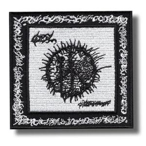 May include: A square embroidered patch featuring a black and white design. The center displays a circular, spiky graphic with intricate black linework on a white background. A thick black border surrounds the center, decorated with stylized, illegible white text.