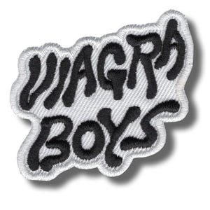 Puede incluir: Un parche bordado que presenta el texto "VIAGRA BOYS" en letras negras, gruesas y estilizadas. Las letras están cosidas sobre una base de tela blanca con un borde blanco a juego que sigue la forma orgánica e irregular del texto.