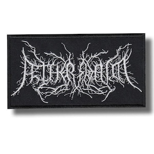 Peut inclure: Un écusson rectangulaire noir brodé avec un fil blanc formant un motif complexe et illisible rappelant des branches. La broderie présente un aspect dense et texturé sur le fond en tissu noir uni de l'écusson.