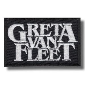Könnte beinhalten: Ein rechteckiger, schwarz bestickter Aufnäher mit dem weißen Schriftzug GRETA VAN FLEET in einer fetten Serifenschrift. Der Aufnäher hat einen dicken, schwarz umkettelten Rand und einen strukturierten Stoffhintergrund zur Textilanwendung.