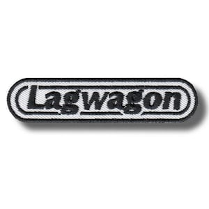 May include: A rectangular embroidered patch with rounded ends featuring the word Lagwagon in bold black lettering. The text is centered within a white background, surrounded by a thick black border, creating a clean and high-contrast design.