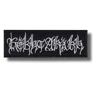 Peut inclure: Un écusson rectangulaire noir brodé avec un fil blanc formant des lettres stylisées, dentelées et complexes au centre. L'écusson présente une bordure finie et nette ainsi qu'une texture tissée plate sur l'ensemble du motif.