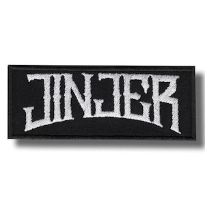 May include: A rectangular embroidered patch with a black background and white stitching. The text JINJER is displayed in a stylized, jagged font across the center of the patch, featuring a distinct arched layout with a thick black border.