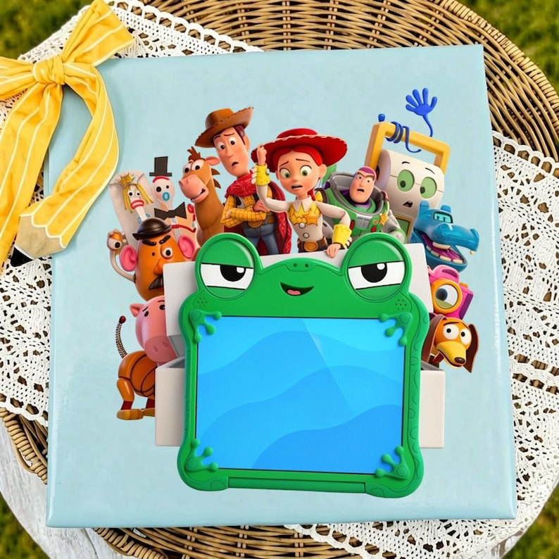 May include: A light blue square box featuring a colorful graphic of Toy Story characters including Woody, Jessie, and Buzz Lightyear. A bright green frog-shaped tablet case with a blue screen is centered on the front of the box.
