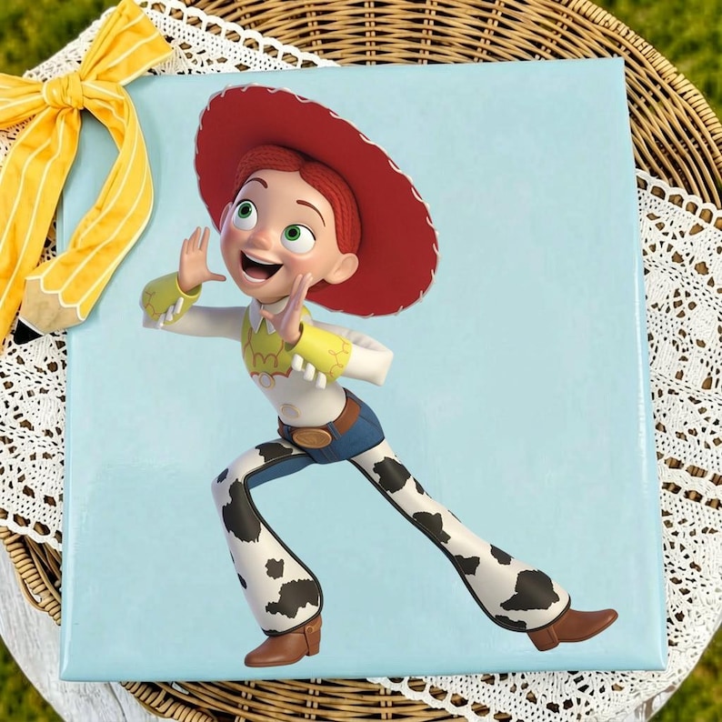 May include: A square light blue board featuring a graphic of a cartoon cowgirl character with red hair, a large red hat, a yellow shirt with white cuffs, and white pants with black cow-print spots. The character is posed with hands near the face.