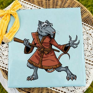 May include: A square light blue sign featuring a cartoon illustration of a gray rat wearing a brown robe and holding a wooden staff. The rat has a long tail and is posed in a dynamic stance. A yellow ribbon is attached to the top left corner.