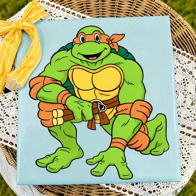 May include: A square canvas print featuring a cartoon illustration of a green Teenage Mutant Ninja Turtle character with an orange mask and arm bands, holding nunchucks, set against a light blue background with a yellow striped pencil bow.